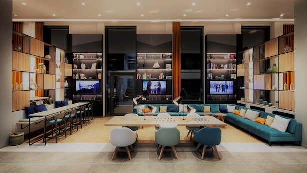 A modern living room with a sofa, chairs, a coffee table, and a TV. There are bookshelves on either side of the room. - Holiday Inn Hamburg - Hafencity by IHG (Hamburg)