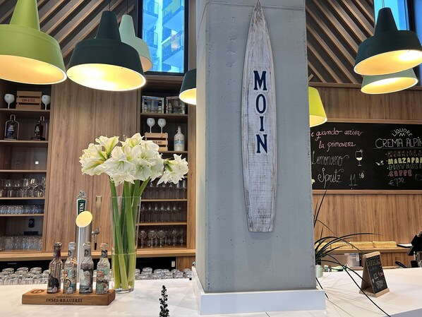 A bar area with a wooden interior, a chalkboard menu, and a large wooden sign with the word "MOIN". - Holiday Inn Hamburg - Hafencity by IHG (Hamburg)