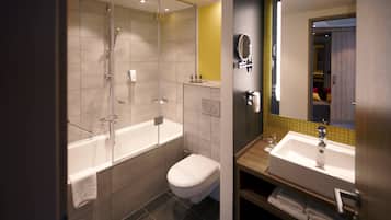 A modern bathroom with a glass-enclosed shower, a separate toilet, and a vanity with a mirror.