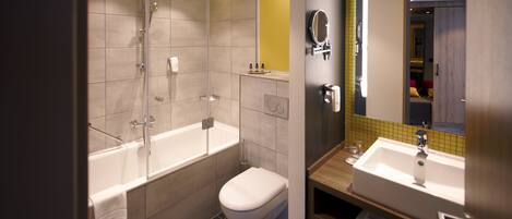 A modern bathroom with a glass-enclosed shower, a separate toilet, and a vanity with a mirror.
