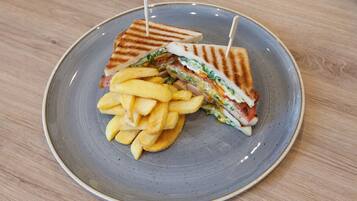 Une assiette avec un sandwich grillé et des frites.