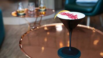 Ein Martini-Glas mit einer Garnitur auf einem Kupfertablett in einem modernen Ambiente.