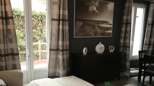 Un salon moderne avec un canapé, une table basse et un téléviseur fixé au mur.
