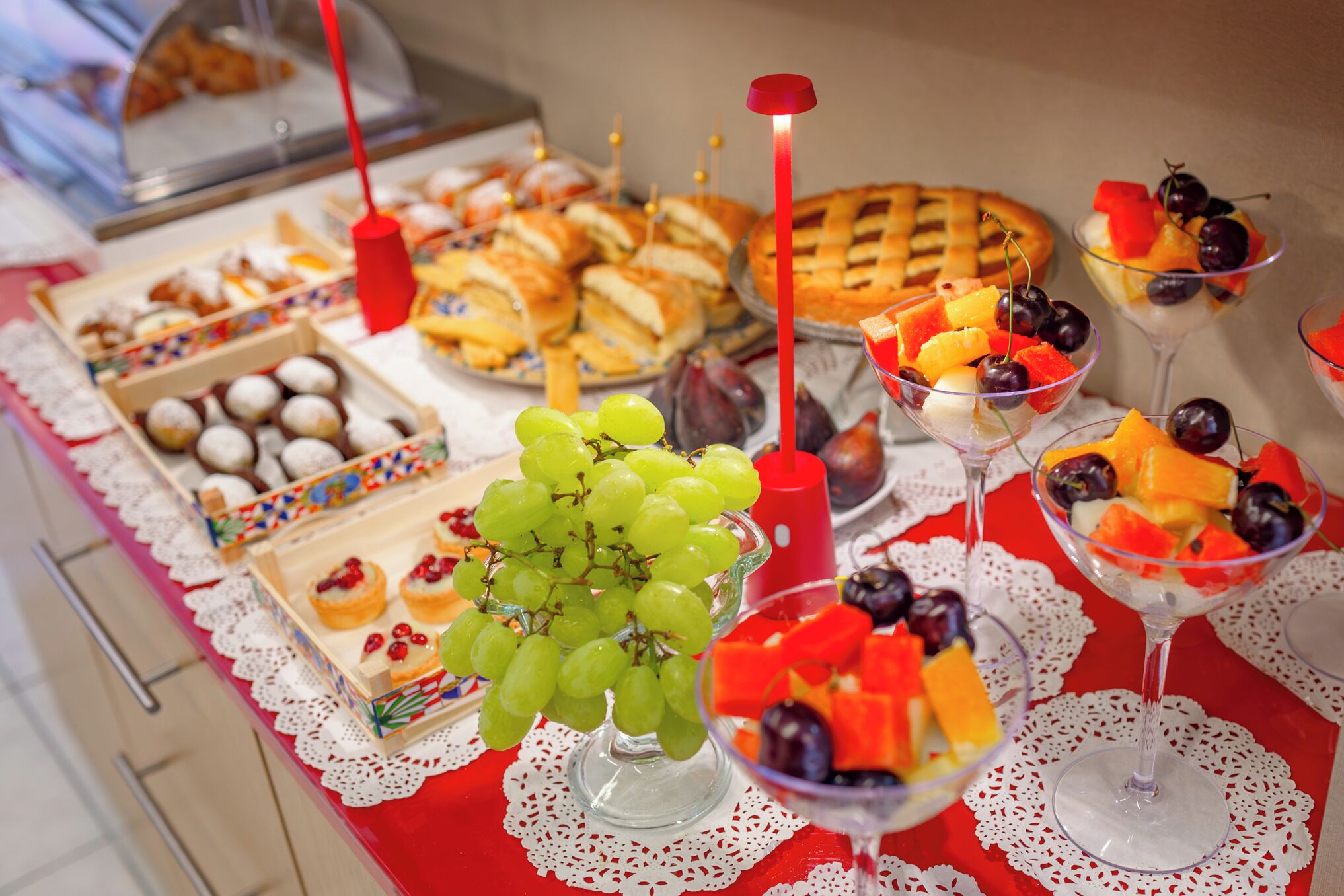 A buffet with various food items including pastries, fruits, and desserts.