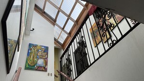 Un escalier avec une main courante en bois, une rampe en métal et un tableau accroché au mur.