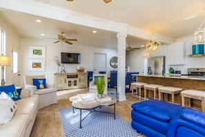 Relax in this stylish living area with a sofa, armchair, and coffee table, perfect for unwinding and enjoying the TV or a meal at the bar.