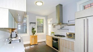A modern kitchen with stainless steel appliances, wooden cabinets, and a central island.