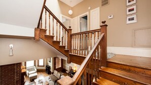 A multi-level home interior with a wooden staircase, a dining area, and a living space.