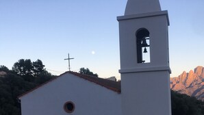 A small white church with a bell tower, a cross on top, and a moon in the sky. - Typical Corsican property, 3 bedrooms sleeps 6, view of the Gulf of Porto (Osani)