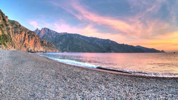 A pebble beach with a mountain backdrop and a sunset sky. - Typical Corsican property, 3 bedrooms sleeps 6, view of the Gulf of Porto (Osani)