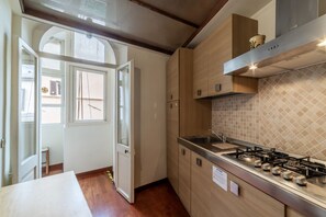 A modern kitchen with wooden cabinets, a gas stove, and a tiled backsplash.