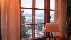 A room with a large window offering a view of a snowy landscape and mountains. - CHALET FINNISH WOOD (Bolquère)