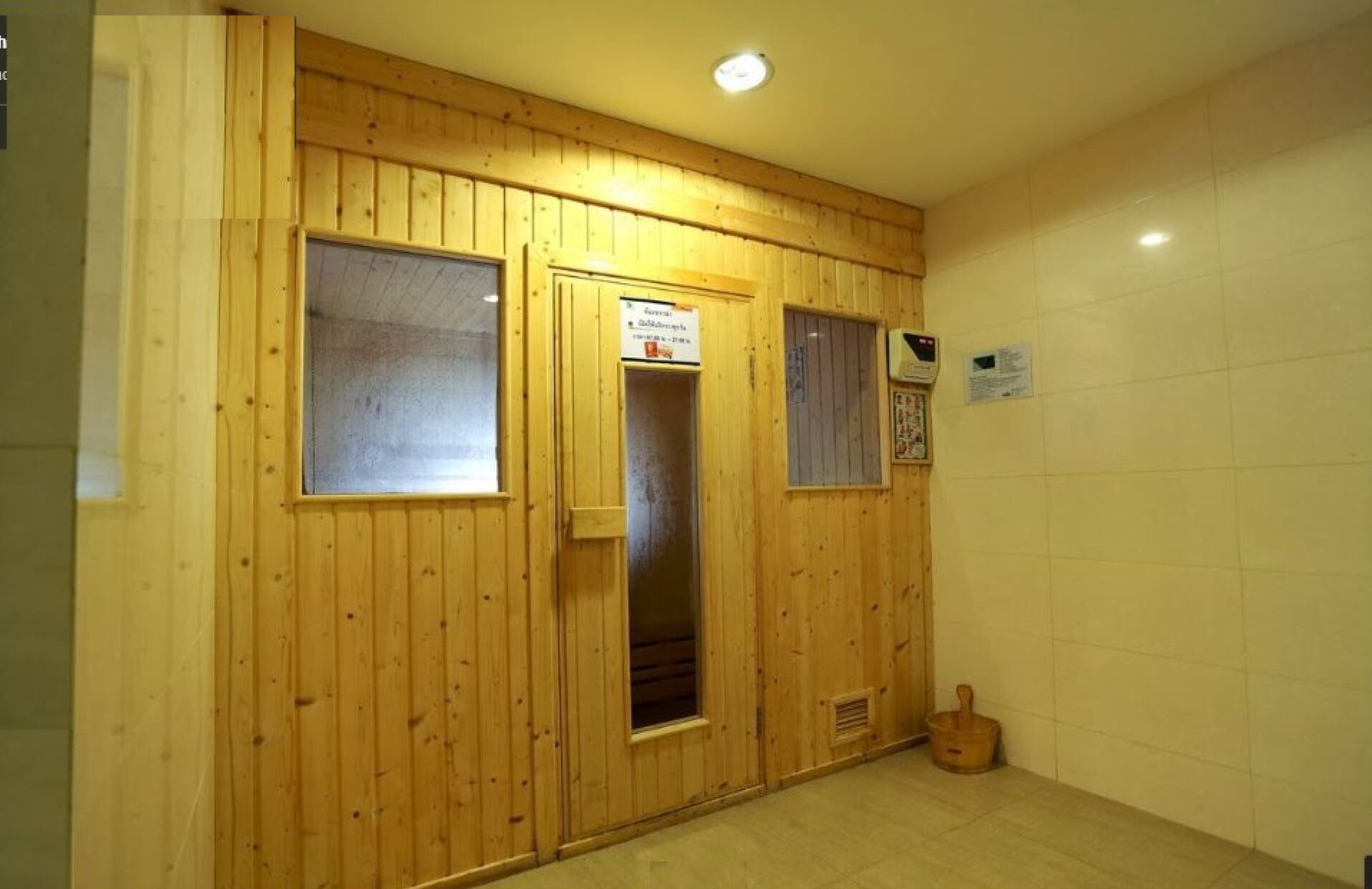 A wooden-paneled room with a tiled floor, a door, and a small window.