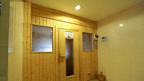 Um quarto com painéis de madeira, piso ladrilhado, uma porta e uma pequena janela.