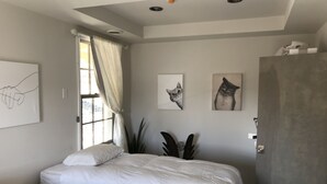 A bedroom with two beds, a window with curtains, and wall art. - Waterfront Keuka Lake INCREDIBLE VIEWS • BOAT SLIP • TWO BALCONIES 3rd floor (Hammondsport)