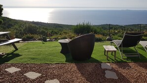 Un pati amb mobles d'exterior que dona a una vista panoràmica del mar.
