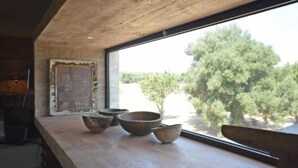 A modern kitchen with a large window, a rustic wooden countertop, and a view of trees outside. - LUXURY VILLA 4 BEDROOMS NEAR TO TORRE GUACETO BEACHES, CAROVIGNO,  OSTUNI (Serranova)