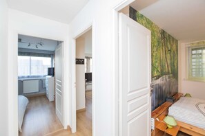 Un dormitorio con cama de madera, una mesita de noche y ventana con vista a un bosque.