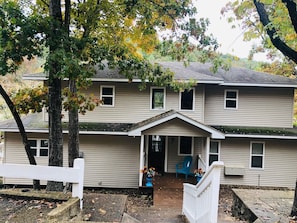 A two-story house with a front porch, a covered entryway, and a small front yard.