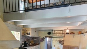 Una cocina con comedor, una escalera y vista al exterior.
