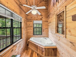 A wooden cabin bathroom with a bathtub, a ceiling fan, and large windows. - Country Charm B - Pet Friendly Cabin in city limits of Helen GA (Helen)
