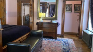 Un dormitorio con cama, cómoda, espejo y ventana.