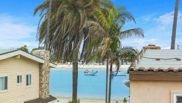 Una propiedad frente a la playa con chimenea de piedra, piscina y vista al mar.