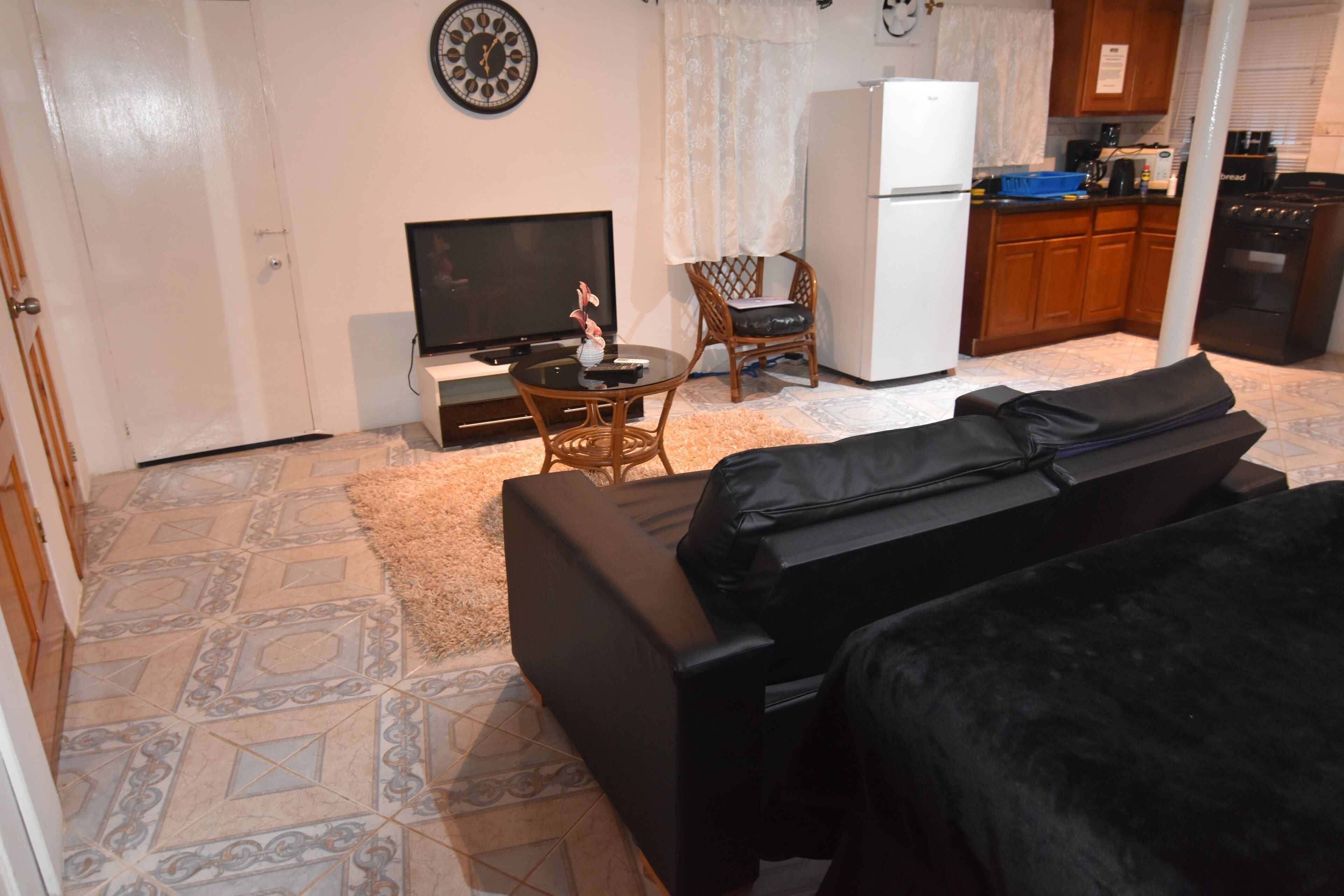 Un espacio habitable compacto con sofá, televisión, mesa de comedor y zona de cocina.