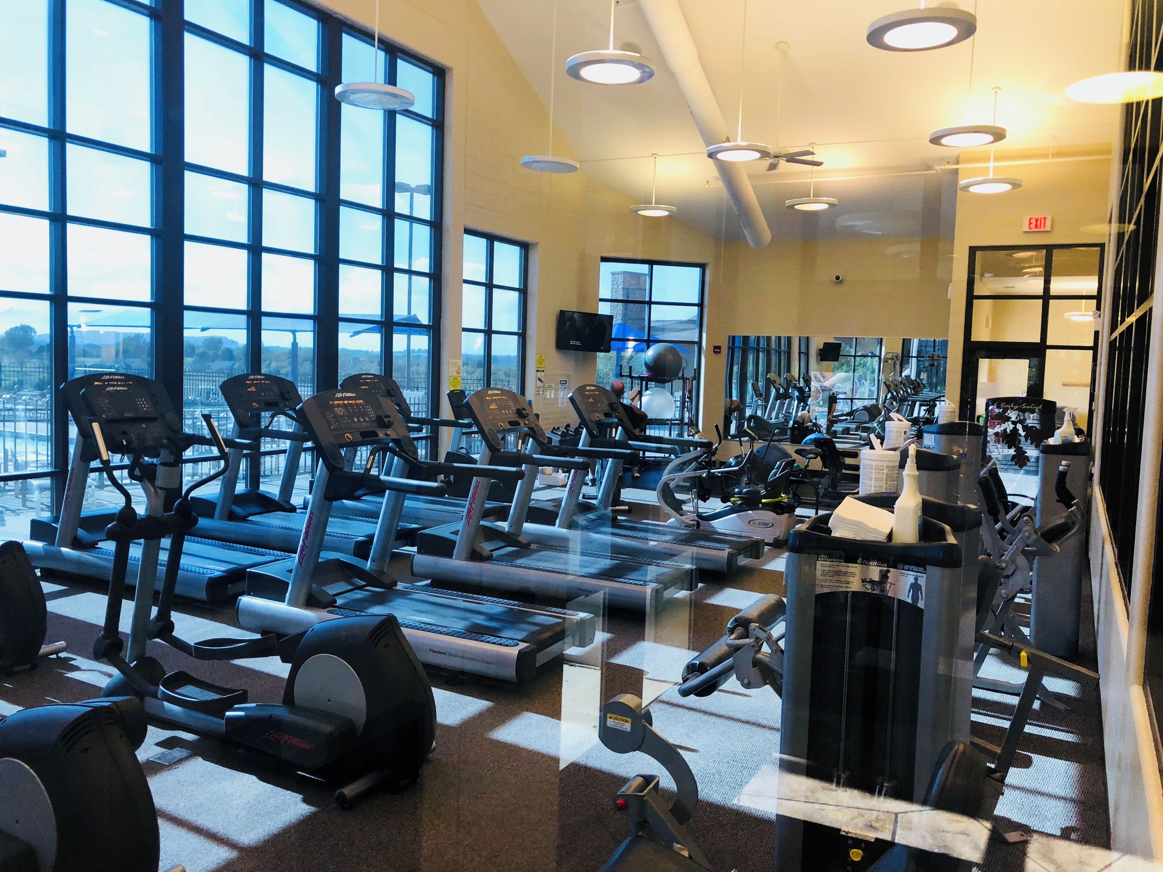 A gym with multiple treadmills, stationary bikes, and weight machines.