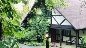 A traditional house with a garden, a wooden bench, and a lamp post.