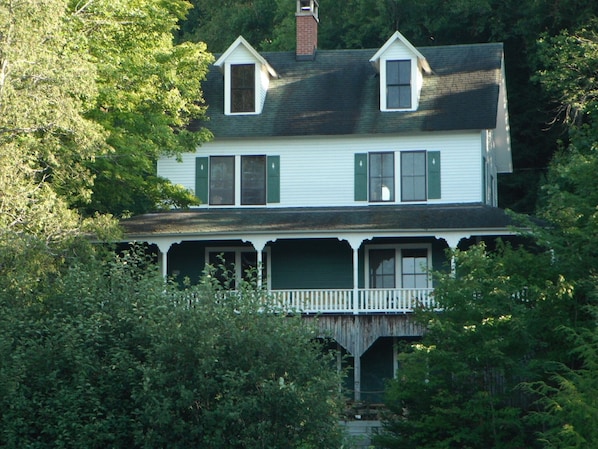 A two-story house with a porch and a small balcony.