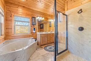 Een bad/douchecombinatie, een bubbelbad, een haardroger, handdoeken