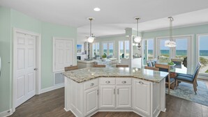A spacious kitchen with a large island, white cabinetry, and a view of the beach. - Stunning Beachfront • Private • Remodeled • Game Room • 5BR • 200+5-Star Reviews (Gulf Shores)