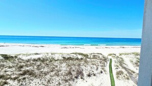 A beach view with sand dunes and a clear blue sky. - Stunning Beachfront • Private • Remodeled • Game Room • 5BR • 200+5-Star Reviews (Gulf Shores)