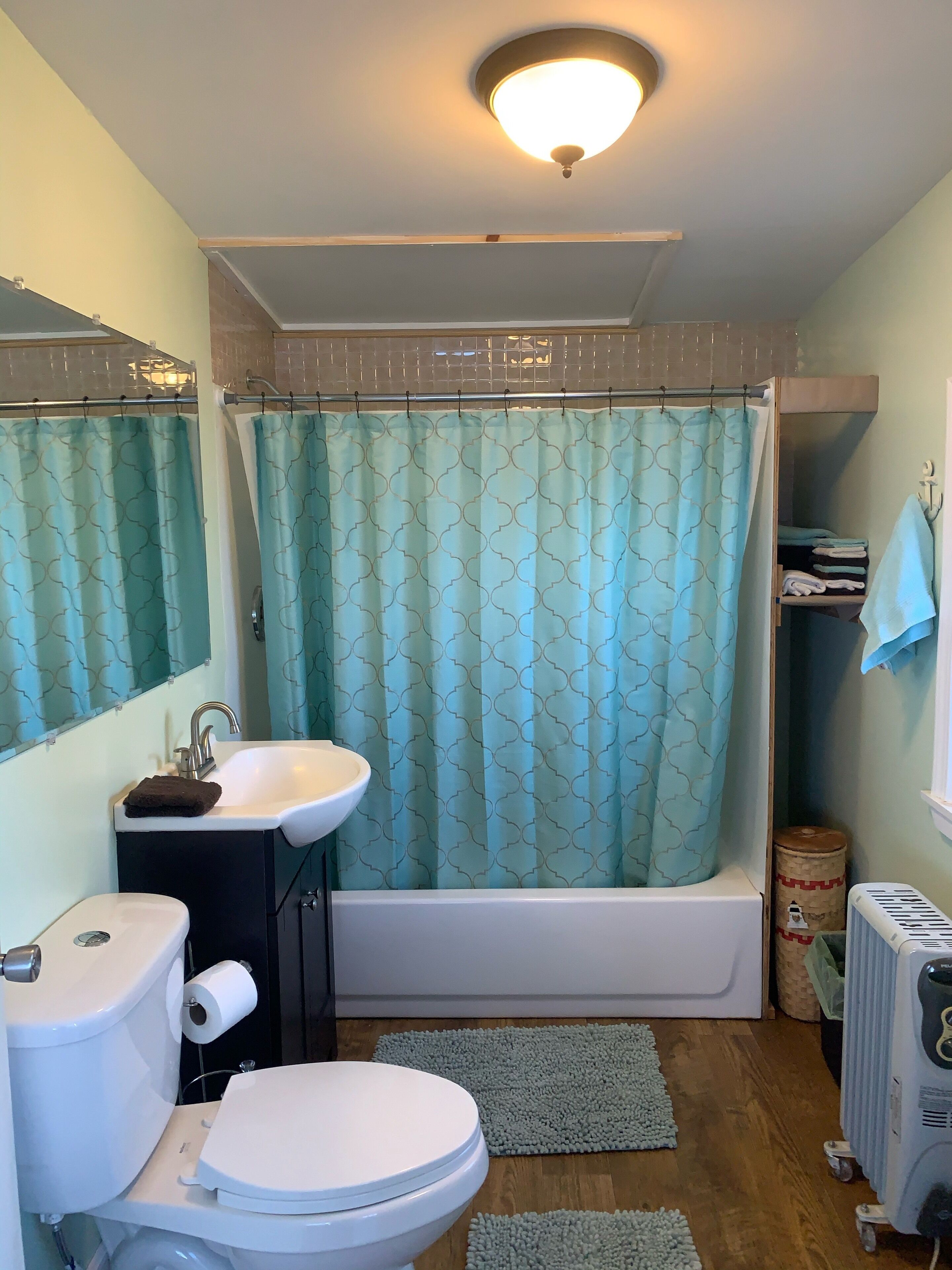 Een badkamer met toilet, wastafel en bad.