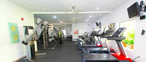 Een sportschool met meerdere loopbanden en fitnessapparatuur.