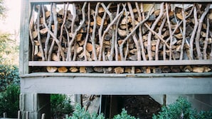 A wooden structure with a grid of logs and branches. - Walk to DT Highlands | Designer Cabin | Fireplace | Fenced Yard | Dog Friendly (Highlands)