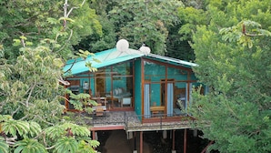 A treehouse with a glass enclosure, a dining area, and a bedroom. - Above the Gulf House: Spectacular Ocean View! (Monteverde)