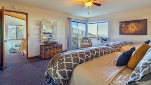 A bedroom with a large bed, a telescope, and a view of the outdoors.