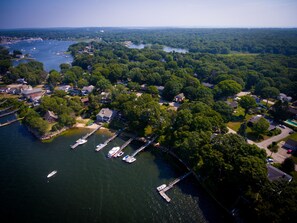 An aerial view of a lakeside community with houses, docks, and boats.