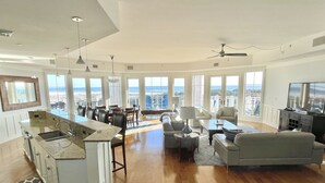 A spacious living area with a kitchen, dining area, and seating with a view of the ocean. - Direct Gulffront! BREATHTAKING 270 degree Ocean Views! Large 2600 sqft 3bdrm! (WaterSound Beach)