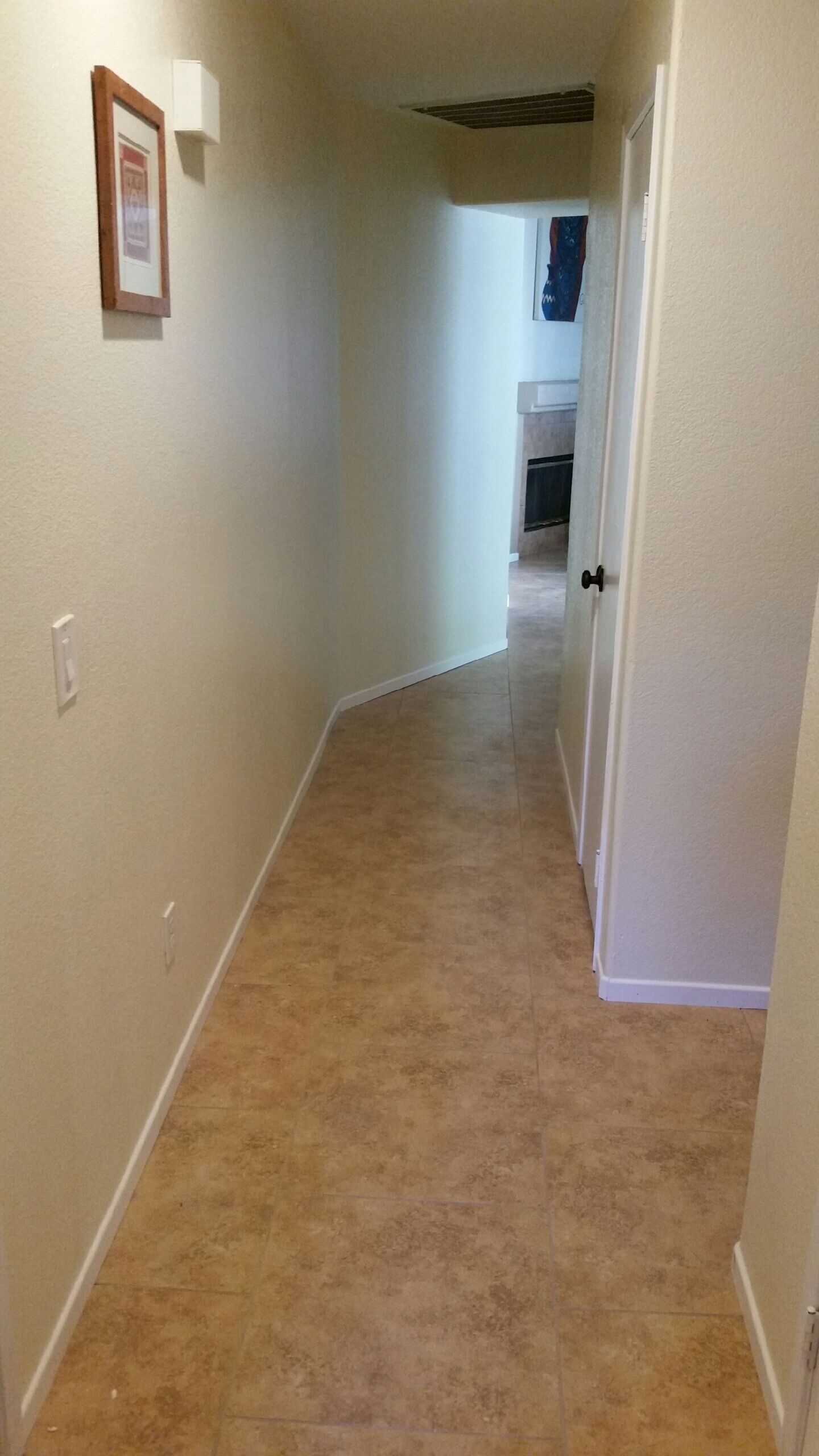 Un couloir étroit aux murs et au tapis de couleur beige.