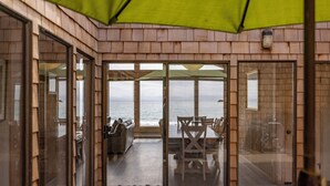 Un espacio al aire libre cubierto con vistas al mar, una mesa de comedor y sillas.