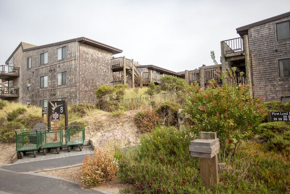 A residential building with a wooden exterior, multiple balconies, and a sign indicating a return to a station.