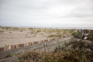 A beach with a wooden fence and a boardwalk leading to the water.