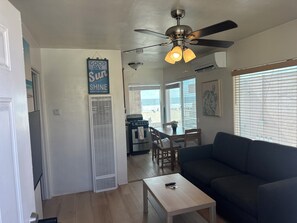 A living room with a ceiling fan, a dining area with a table and chairs, and a kitchen with a stove. - Near Ocean Front!, Views, Spa, AC, Best MB Location! (San Diego)