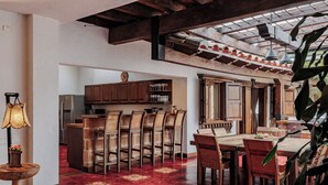 Una cocina amplia con armarios de madera, un comedor con piso rojo y un ventanal grande.