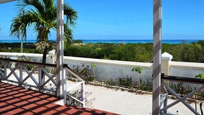 Un balcon donnant sur l’océan, avec une balustrade blanche.