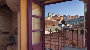 Een balkon met uitzicht op traditionele gebouwen en een stenen muur.