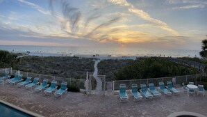 A poolside area with lounge chairs and a view of the beach and sunset. - Oceanfront! Heated Pool! Free WiFi & Cable! Bidets! Deluxe Outdoor Kitchen! Oceanway 203! (Indian Rocks Beach)